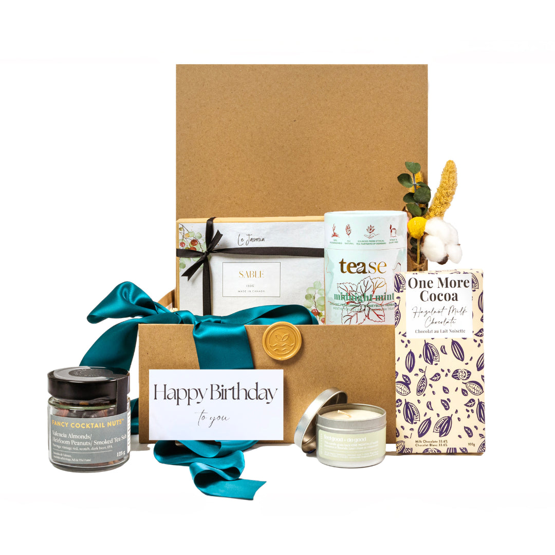 birthday wishes gift basket with gourmet sable cookies, mint tea, handcrafted hazelnut chocolate bar, luxury candle and cocktail nuts, with a Happy Birthday notecard 