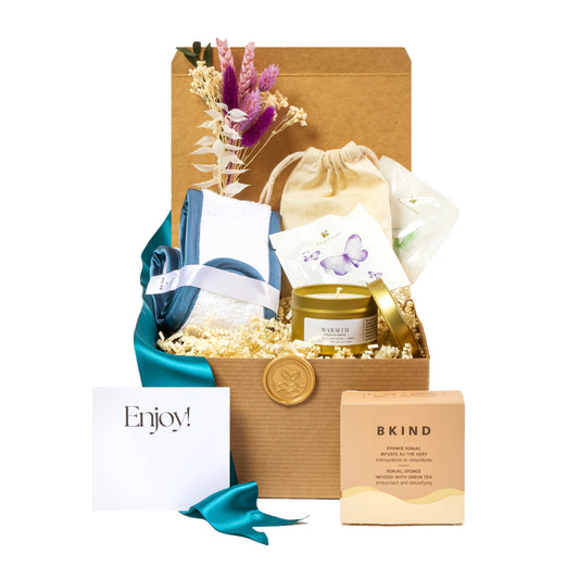 Send the ultimate relaxation care package featuring aa luxury headband, mini artisanal soy candle, luxury tea bags, and a kjonac sponge. 