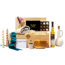 Elegant housewarming gift basket featuring premium, locally-made items, including artisanal chocolates, olive oil, handmade pottery, natural beeswax candles, a woven throw blanket, wooden coasters, and a mini bottle of gourmet seasoning. Packaged sustainably with a teal ribbon and 'Thank You' card. Perfect for corporate gifting, client appreciation, or home celebration. Curated by a women-owned, Toronto-based small business promoting eco-friendly, zero-waste practices