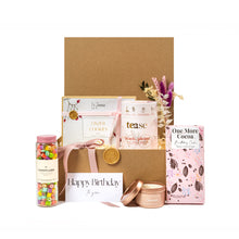 Charming birthday gift basket with eco-friendly packaging, featuring an assortment of locally-sourced treats, including Linzer cookies, artisan chocolate bar, loose-leaf tea blend, colorful candy jar, and a scented candle. Adorned with a pink ribbon, dried flower arrangement, and a 'Happy Birthday' card, making it a perfect gift for friends, family, or corporate birthday celebrations. Curated by a Toronto-based, women-owned small business committed to sustainability and zero-waste gifting