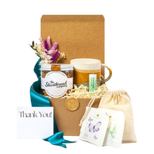 Deluxe Best Wishes gift basket featuring artisan shortbread cookies, ceramic mug, lip balm, premium tea sachets, dried flower arrangement, teal ribbon, and eco-friendly packaging. Curated with locally sourced, sustainable products from small businesses, this plastic-free gift box offers a warm and thoughtful way to say thank you