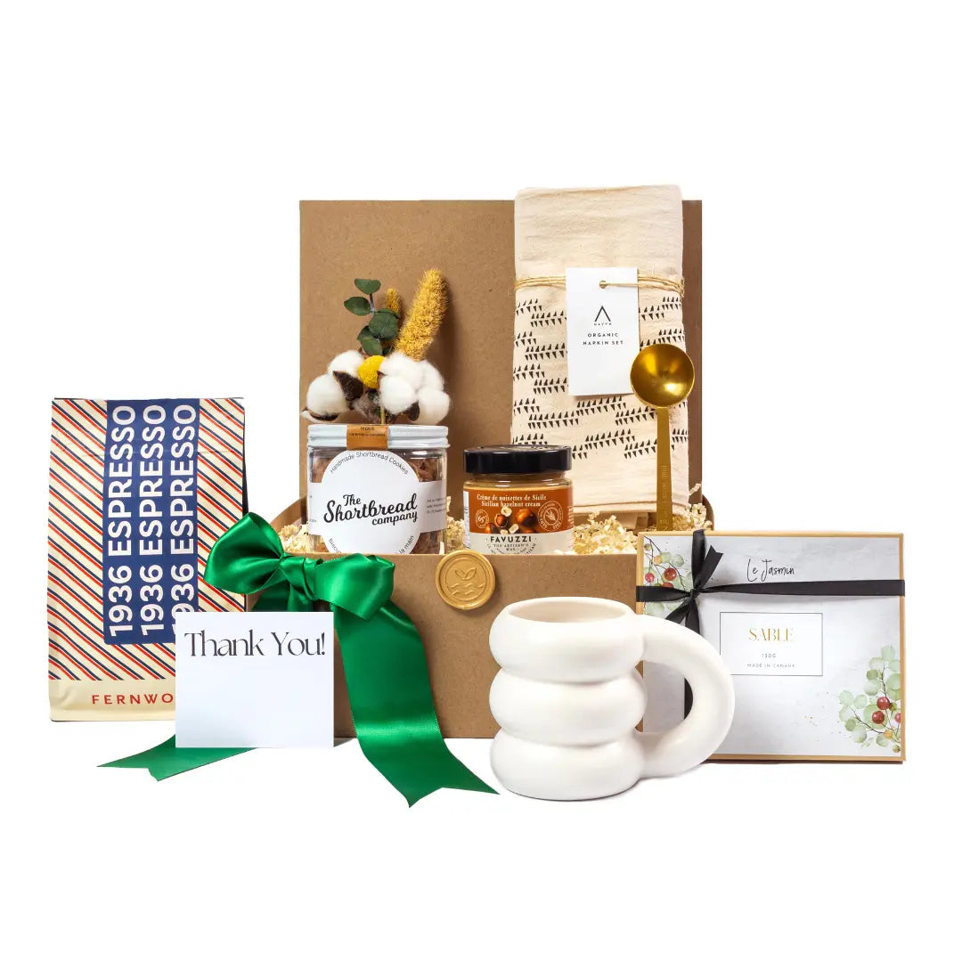 Cloud mug, sable cookies,  gold stainless steel spoon, favuzzii  hazelnut cream, shortbread cookies and espresso beans in a kraft box with  a green ribbon 