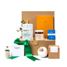 premium relaxation gift basket with vegan notebook, luxury soy candle, midnight mint tea, artisanal bath bomb and luxurious matches packaged in a sustainable box with a satin ribbon and seasonal greenery