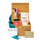 Exterior of the gift kraft gift box with  a blue ribbon,  gold stamp and seasonal greenery
