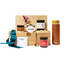 Tea Lovers Executive Gift Box with Gourmet Local Products: Wooden box filled with sustainable, locally curated items including artisanal shortbread, raspberry jam,  loose-leaf tea, eco-friendly tumbler, and a gold tea spoon. Decorated with teal ribbon and dried flowers, perfect as a luxury gift for employees or clients.